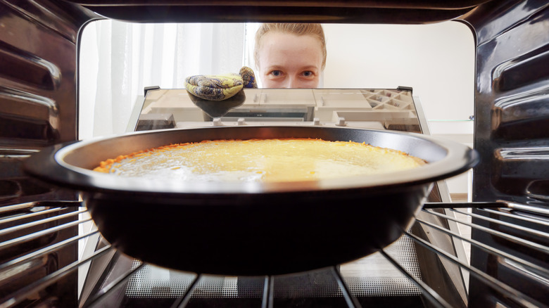 woman peering at cheecake