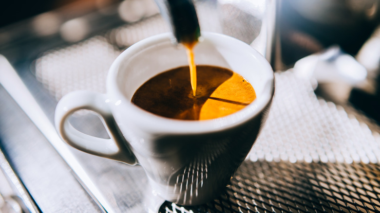 espresso dripping down into a white coffee cup