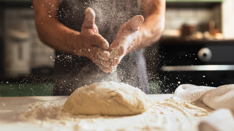 chef making floury pizza dough