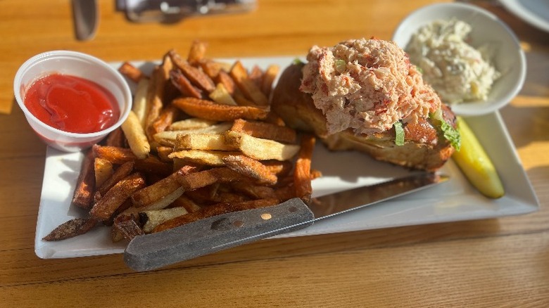 lobster roll and french fries on table