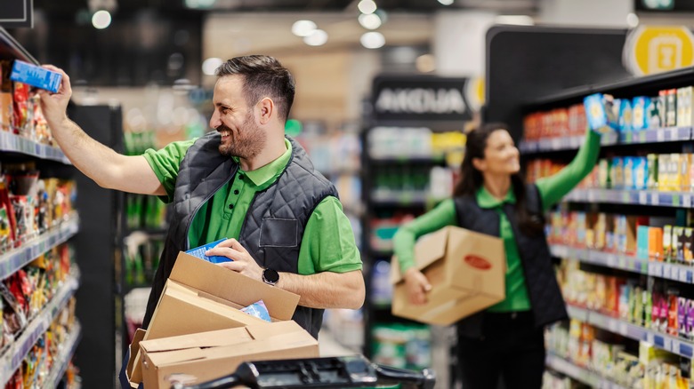 Supermarket employees stocking shelves