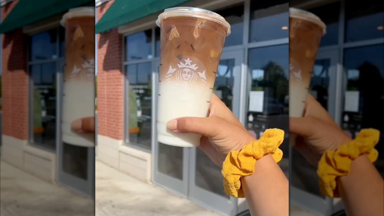 Hand holding a honeycomb macchiato out front