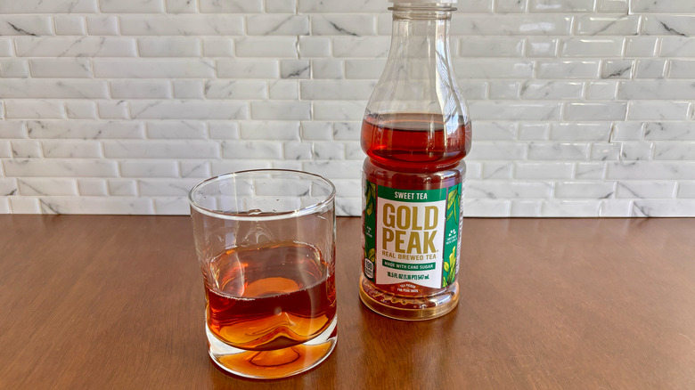 Glass of sweet tea next to Gold Peak sweet tea bottle