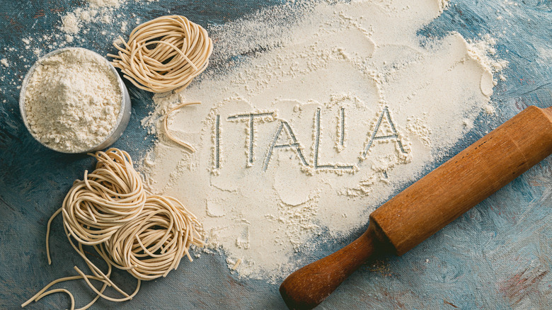 Raw flour with pasta and a rolling pin