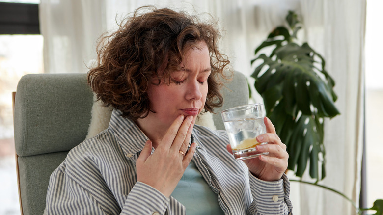 woman sipping a drink with her eyes closed