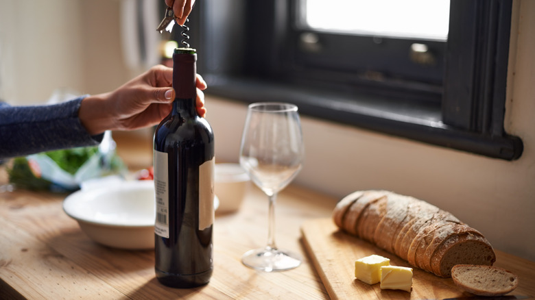 A woman opening a bottle of wine