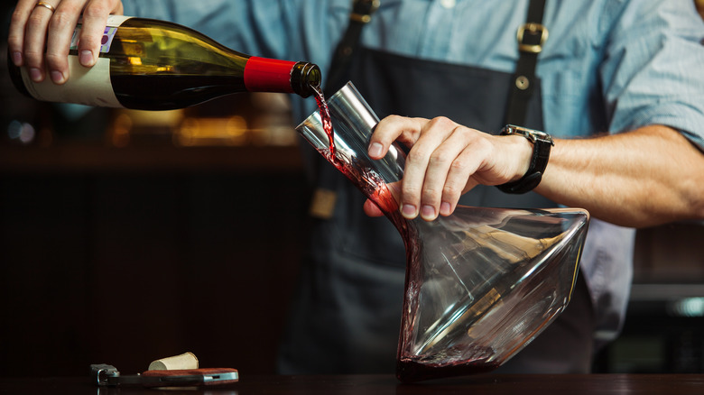 Pouring wine down the side of a decanter