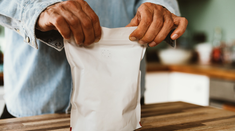 hands holding bag of beans