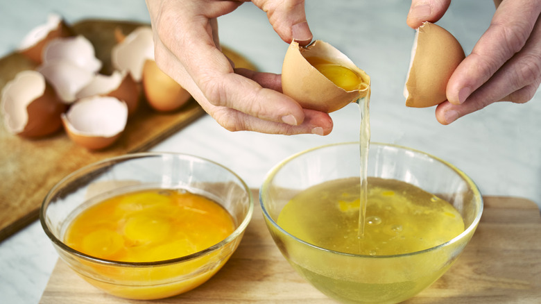 hands separating eggs into bowls