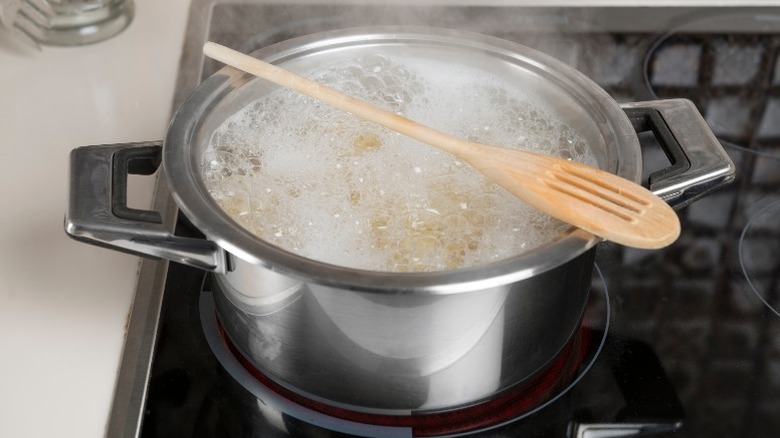 Boiling pasta with wooden spoon