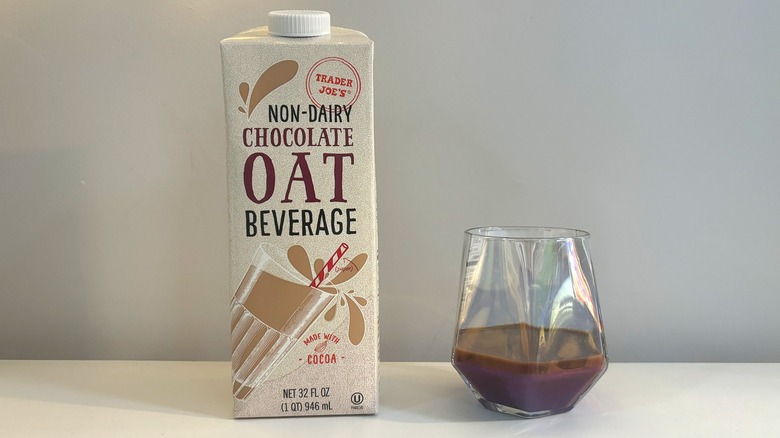 Box and glass of Trader Joe's Non-Dairy Chocolate Oat Beverage on white background