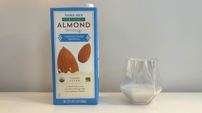 Box and glass of Trader Joe's Organic Unsweetened Almond Beverage on white background