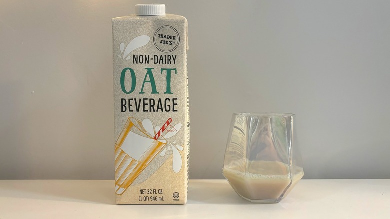 Box and glass of Trader Joe's Non-Dairy Oat Beverage on white background