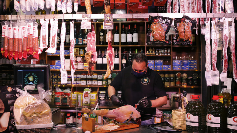 Man cutting ham in a shop 