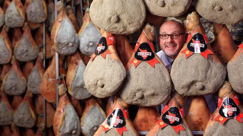 Rows of prosciutto Toscano with a man