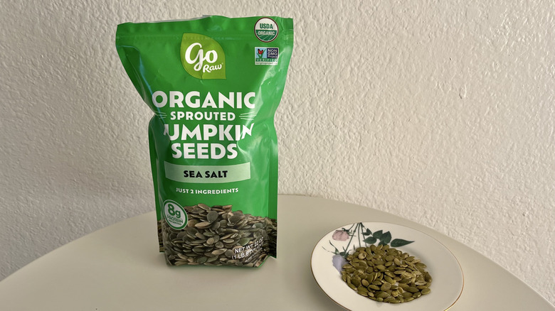 Go Raw organic sprouted pumpkin seeds packaging with white table