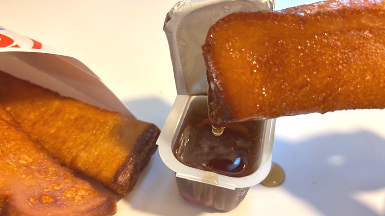 Wendy's French Toast Stick dipped in syrup on white table