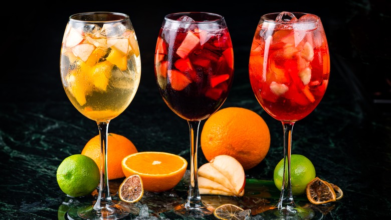 three different sangria recipes in wine glasses