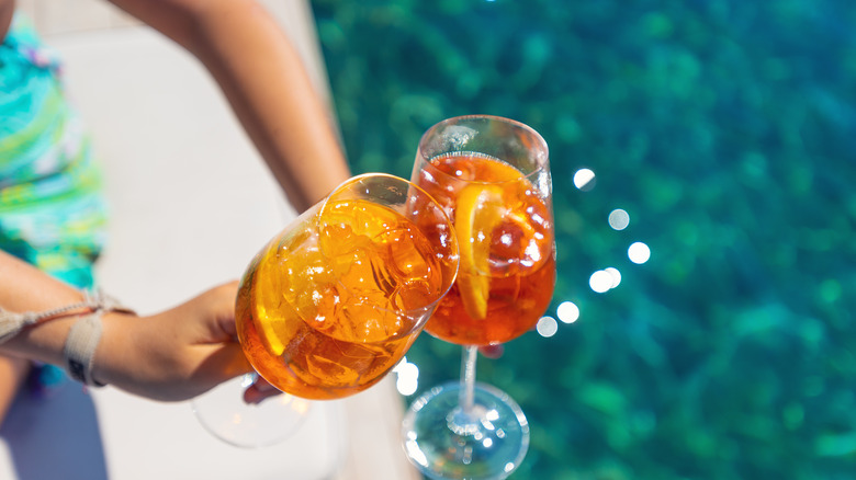 people cheers-ing Aperol spritzes