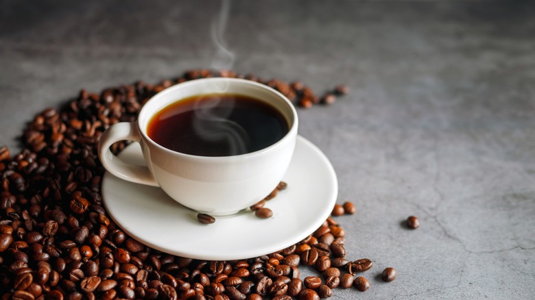 Coffee with beans on gray surface