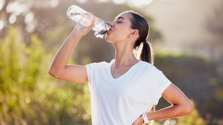 Woman drinking water in nature