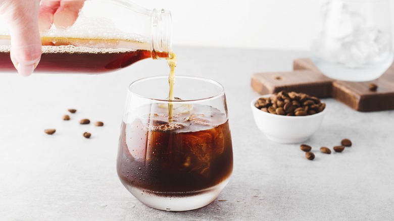 pouring cold brew into a glass