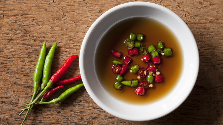 A bowl of fish sauce with chili peppers