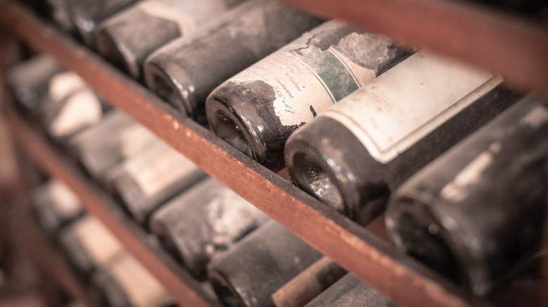 dusty wine bottles on shelf