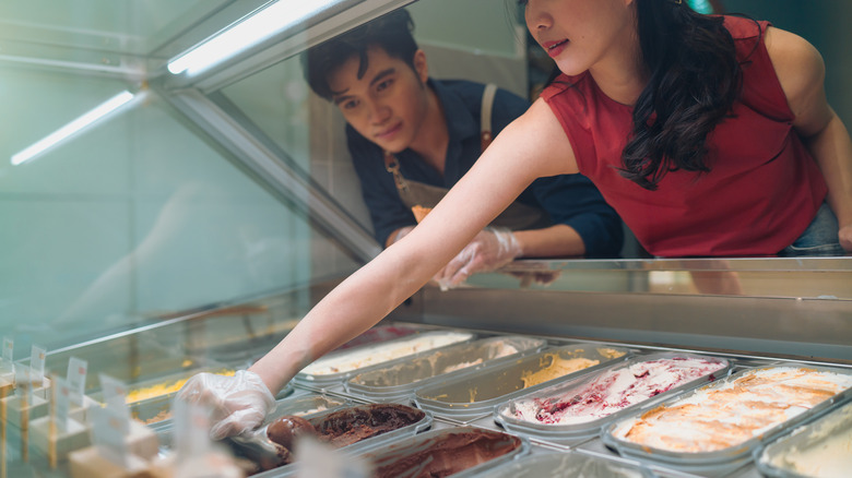 ice cream shop worker instructs on technique