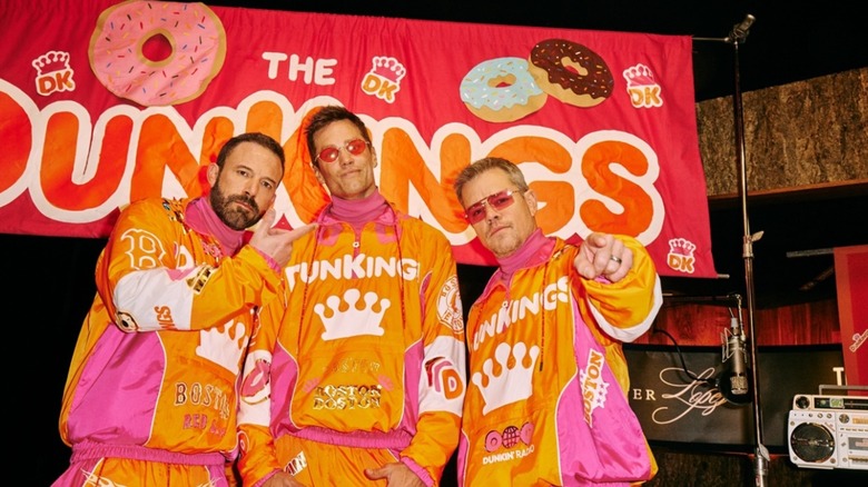 Ben Affleck, Tom Brady, and Matt Damon posing in Dunkin' gear