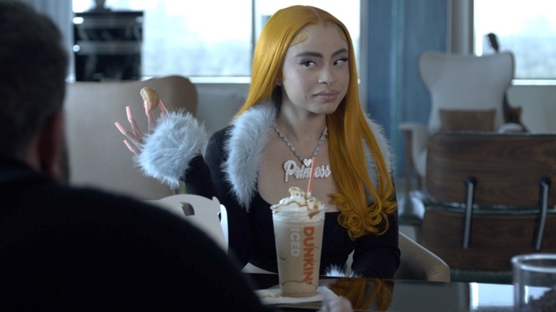 Rapper Ice Spice holds Munchkin in still from Dunkin' commercial