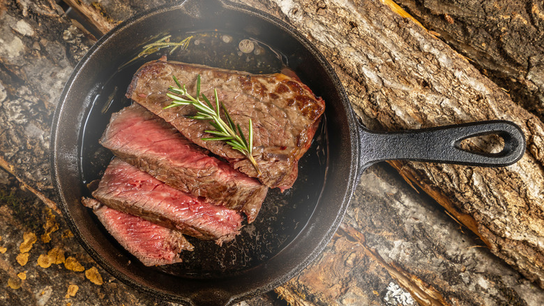 Sizzling steak in cast iron skillet