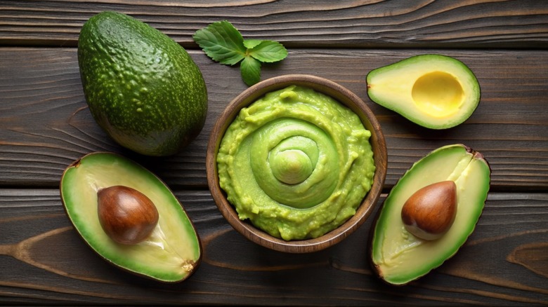 Overview of a bowl of guacamole and avocados