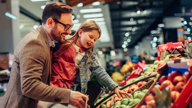 Child and parent buying produce 