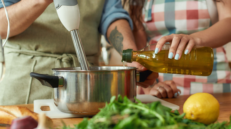 immersion blender in pot with olive oil