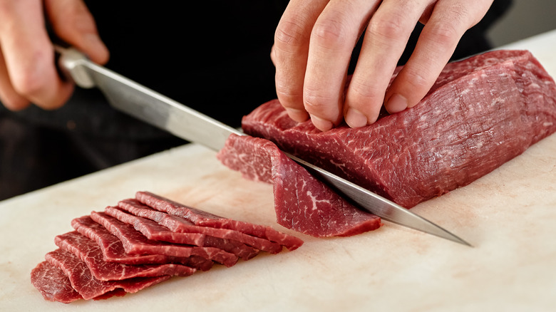 slicing meat with a sharp knife