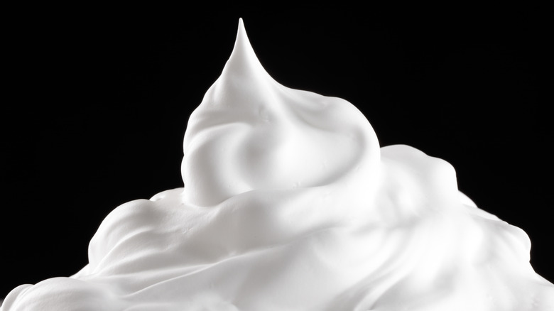 whipped cream against black background