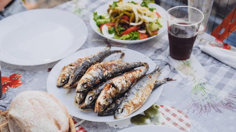 Grilled sardines, salad, and wine