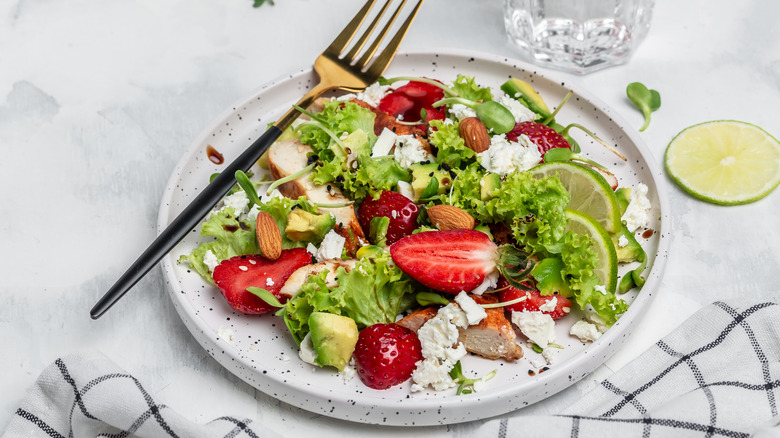 plate of chicken salad and strawberries