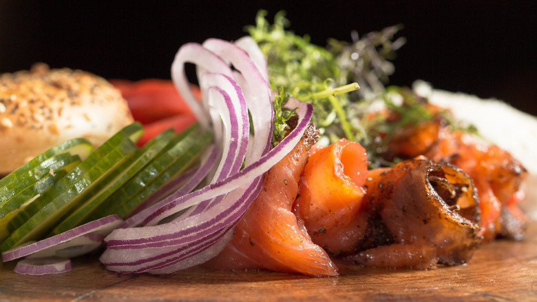 Close-up of smoked salmon, onions, and pickles