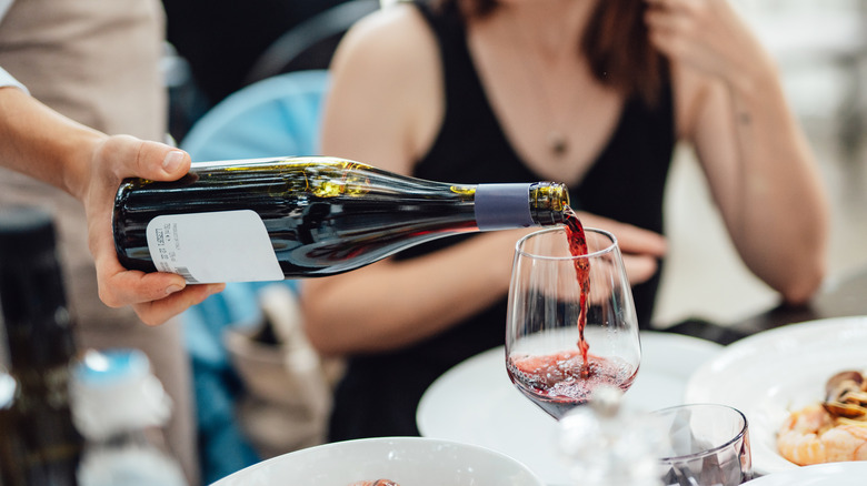 server pouring red wine