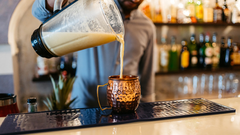 bartender pouring a pina colada