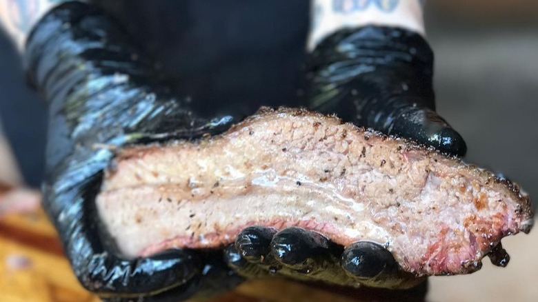 two hands holding brisket