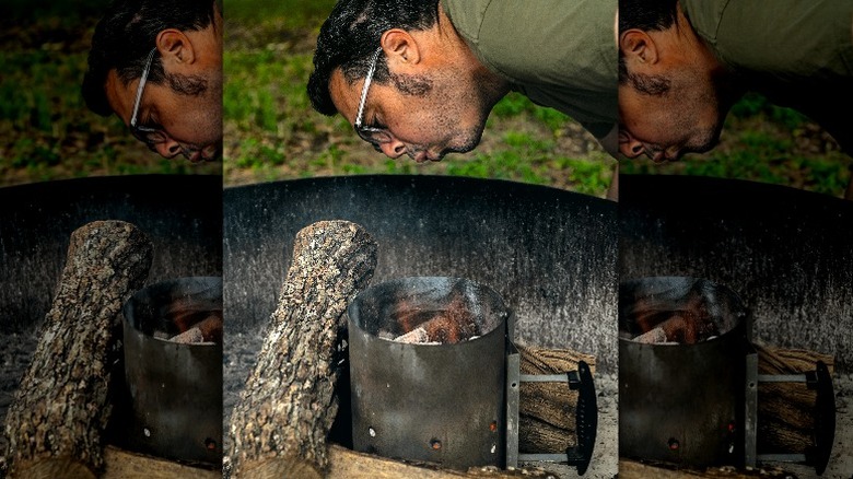 Aaron Franklin blowing on smoke from log fire