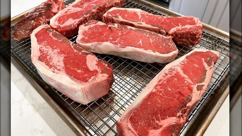 Raw steaks on grill pan