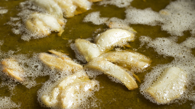 Garlic cloves and olive oil frying