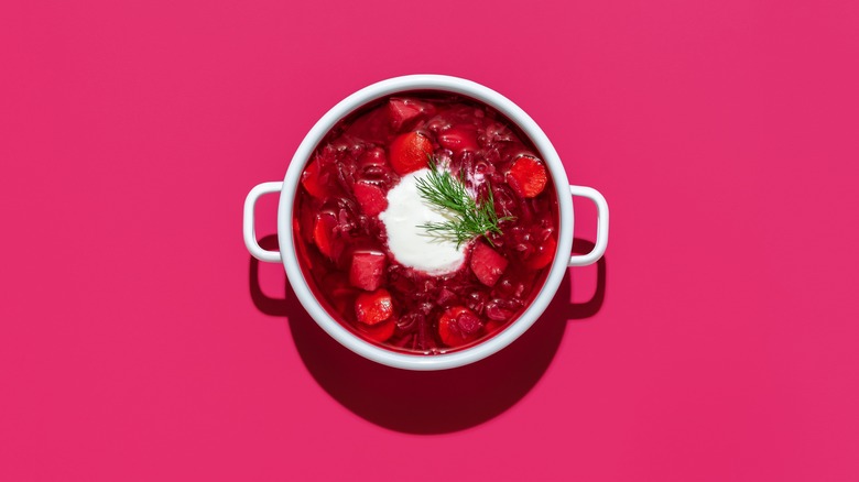 Bowl of garnished beets on a pink background