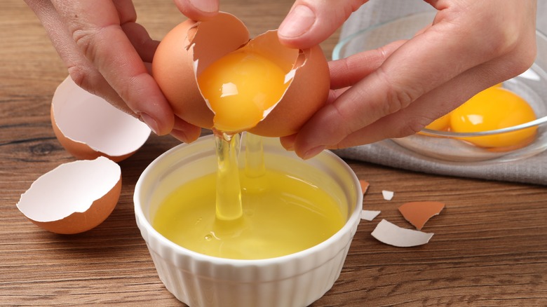 separating yolks from white using the egg shell  over a ceramic ramekin