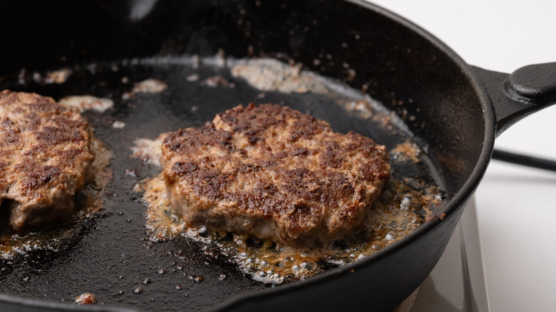 Burger patties cooking in pan