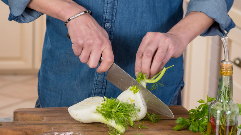 person slicing fennel on board